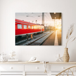 Obraz na płótnie Piękna stacja kolejowa z czerwoną kolejką o zmierzchu
