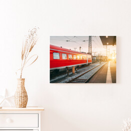 Obraz na płótnie Piękna stacja kolejowa z czerwoną kolejką o zmierzchu