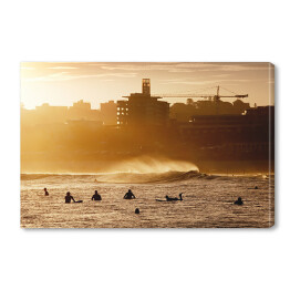 Obraz na płótnie Surfiarze czekający na fale podczas zachodu słońca w Bondi Beach