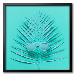 Obraz w ramie Okulary przeciwsłoneczne leżące na liściu palmy - niebieska ilustracja