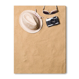 Obraz na płótnie Okulary przeciwsłoneczne, wiklinowy kapelusz i aparat fotograficzny na piasku